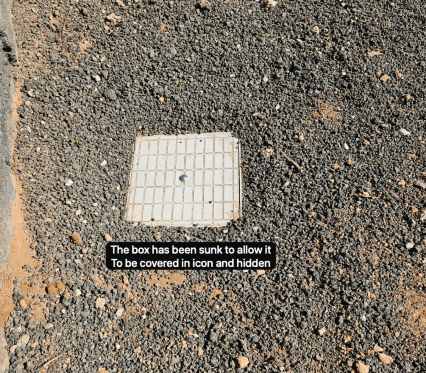 LeakGuard ground box sunk flush with the surface so it can be hidden under gravel